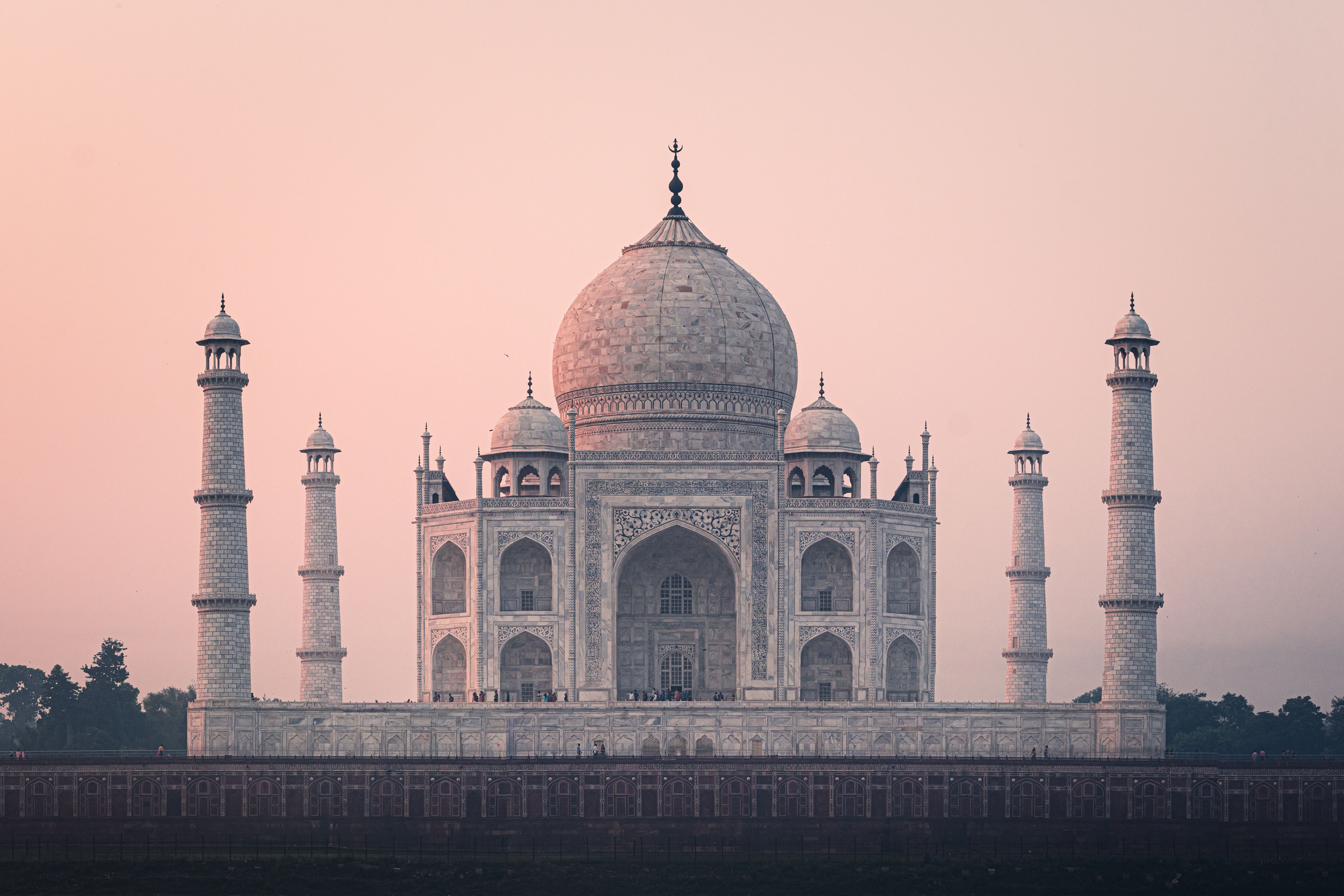 The Taj Mahal and its minarets beneath a soft pink sky, India